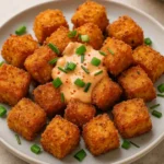 Crispy Bang Bang Salmon Bites on a plate with creamy sauce and fresh chives