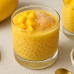 Mango Pomelo Sago dessert in a glass with mango chunks and pomelo topping
