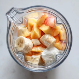 Banana peach smoothie in blender before blending