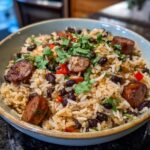 A close-up of a bowl filled with Black Beans Sausage and Rice Skillet, garnished with cilantro.