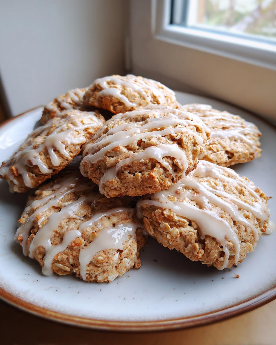 A stack of delicious Cottage Cheese Cinnamon Roll Breakfast Cookies drizzled with icing on a plate.