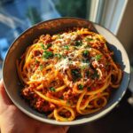 A bowl of Creamy Italian Spaghetti Ground Beef One Pot Meal topped with cheese and parsley.