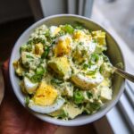 A close-up of creamy Keto Avocado Egg Salad with chopped avocado, hard-boiled eggs, and green onions.