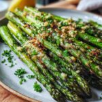 A close-up of delicious Parmesan Roasted Asparagus, seasoned with garlic and fresh parsley, served on a plate.