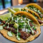 Close-up of delicious Street Tacos with Cilantro Lime Crema, featuring tender meat, fresh toppings, and a drizzle of crema.