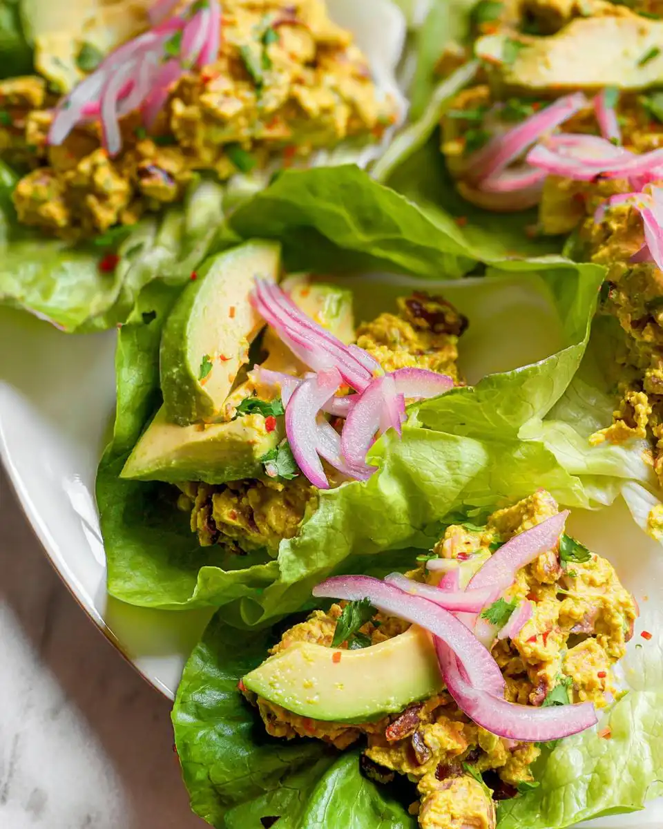 Close-up of Greek Yogurt Chicken Salad Lettuce Wraps topped with avocado and red onion.