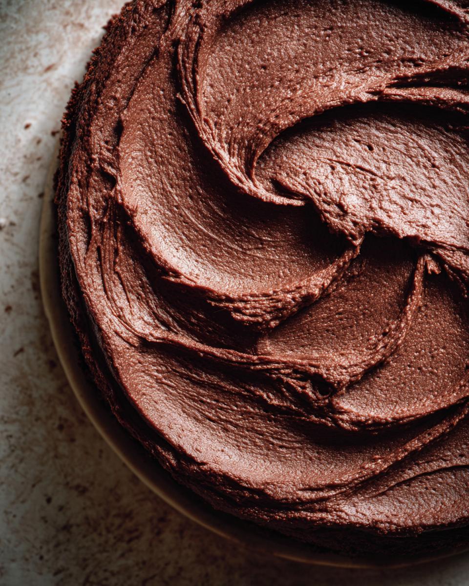 Close-up of rich, swirled chocolate frosting on a Mary Berry Chocolate Cake.