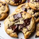 A close-up of a delicious Mary Berry chocolate chip cookie recipe with a bite taken out, showing gooey melted chocolate.