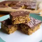 Three delicious Mary Berry Easy Chocolate Flapjacks stacked on a plate, showing the oaty base and chocolate topping.