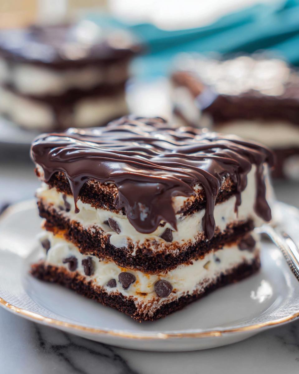 A rich slice of Chocolate Icebox Cake with layers of chocolate cake and cream filling, topped with chocolate ganache.