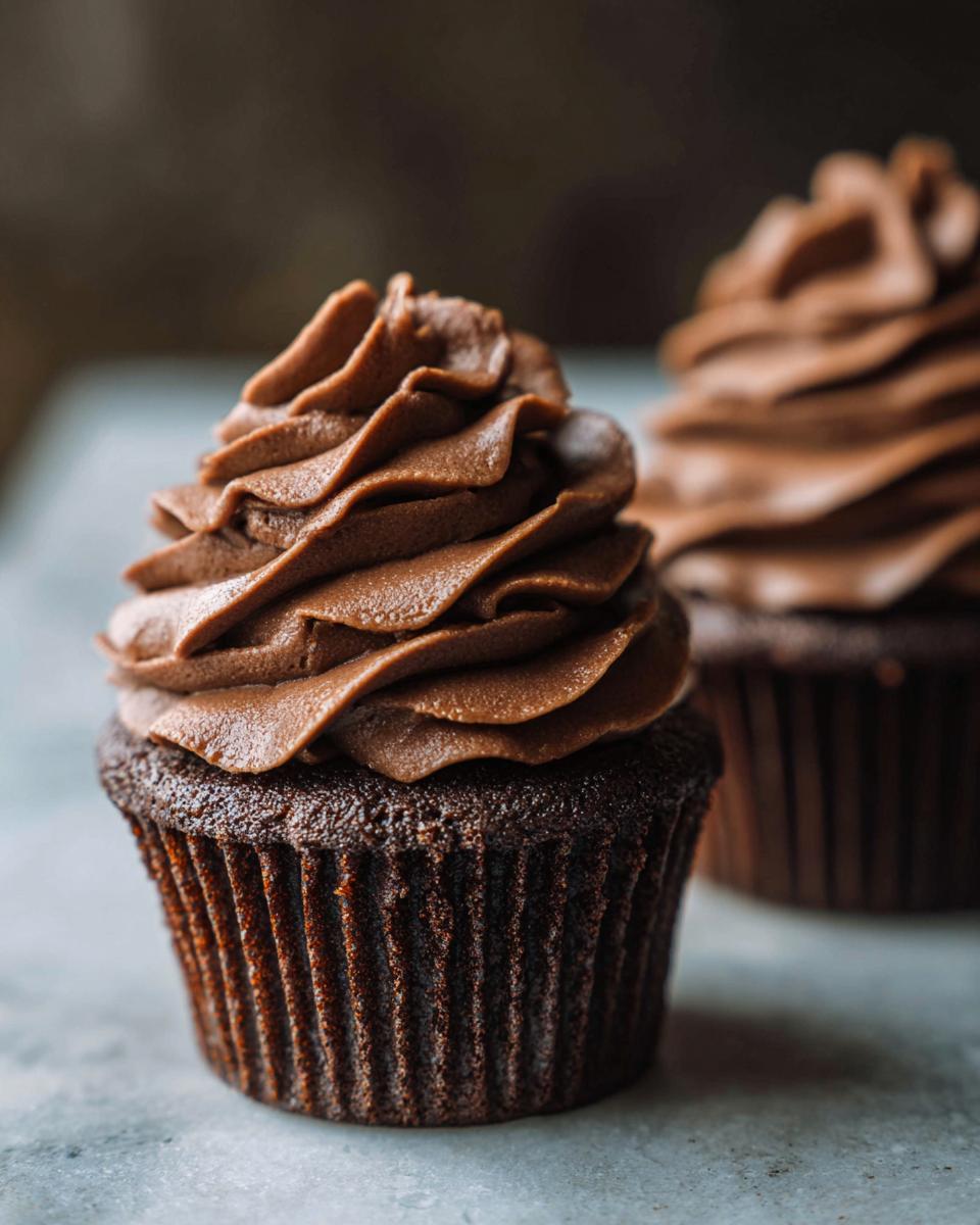 Close-up of a decadent chocolate cupcake topped with swirls of rich chocolate buttercream, inspired by Mary Berry.