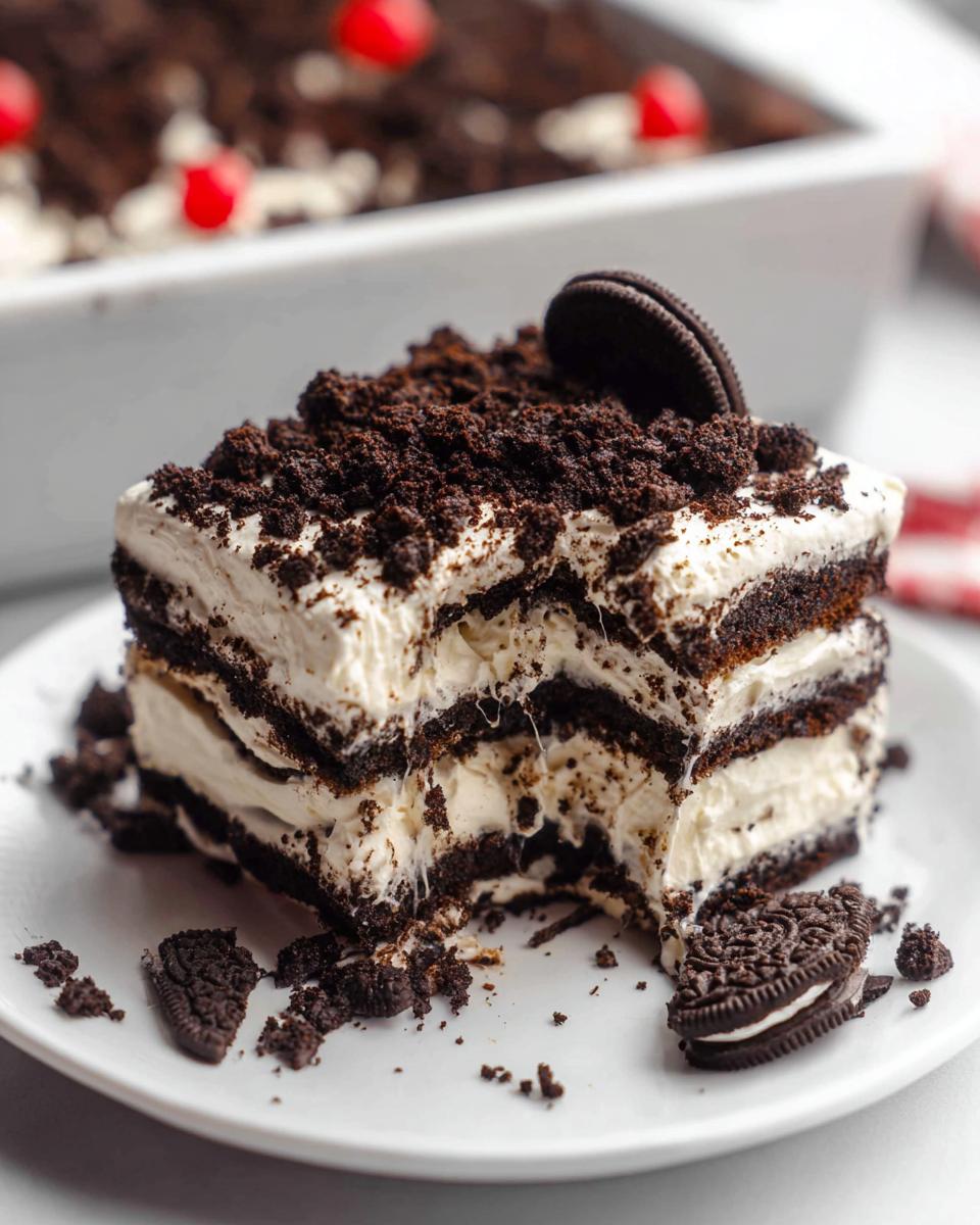 A decadent slice of Oreo Icebox Cake, inspired by Nigella Lawson, with layers of cream and crushed Oreos.